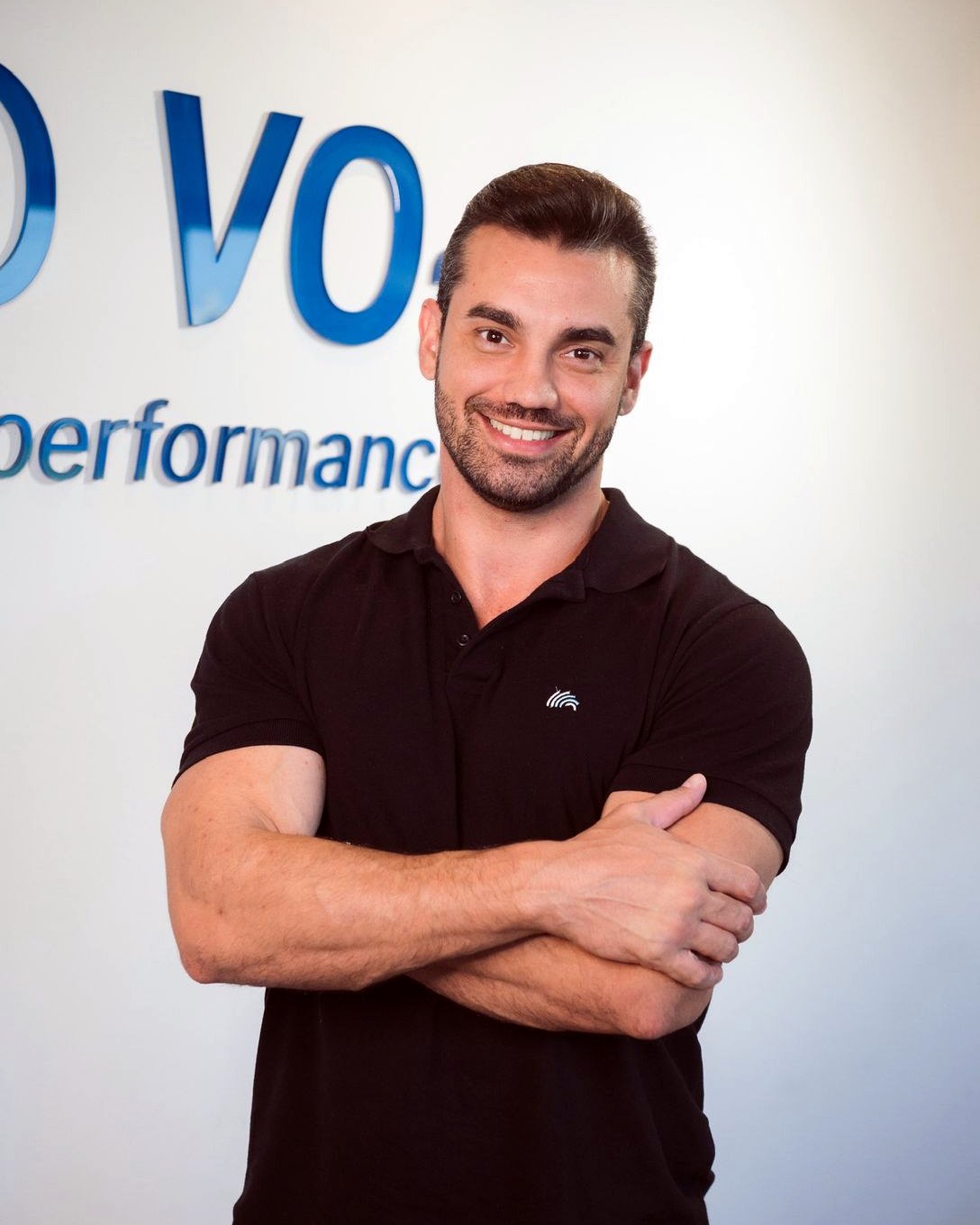 Douglas Lourenço sorrindo, de braços cruzados, no Instituto VO2 Performance