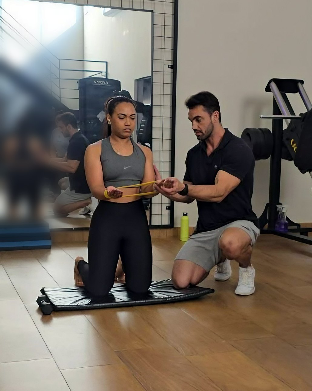 Douglas Lourenço orientando a execução de exercício com elástico durante o treino